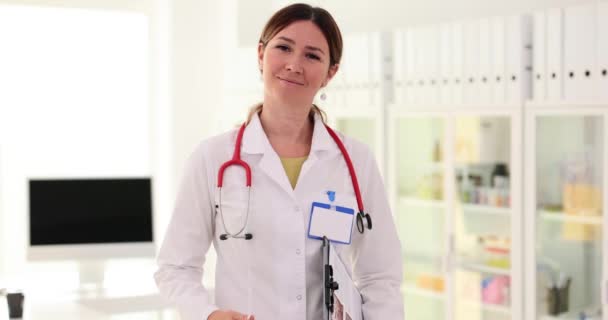 笑顔の女性医師が診療所で手伝ってくれる サービスについて — ストック動画
