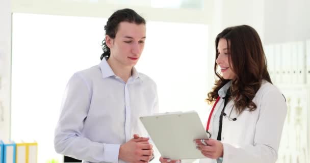 Dokter Dan Pasien Mendiskusikan Hasil Pemeriksaan Fisik Yang Positif Asuransi — Stok Video