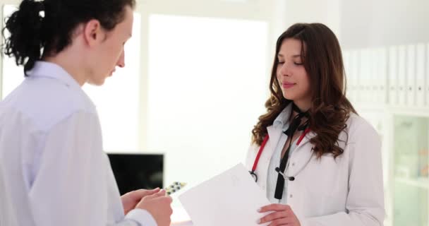 Dokter Verpleegster Geeft Medisch Voorschrift Aan Mens Patiënt Met Gezondheidsproblemen — Stockvideo