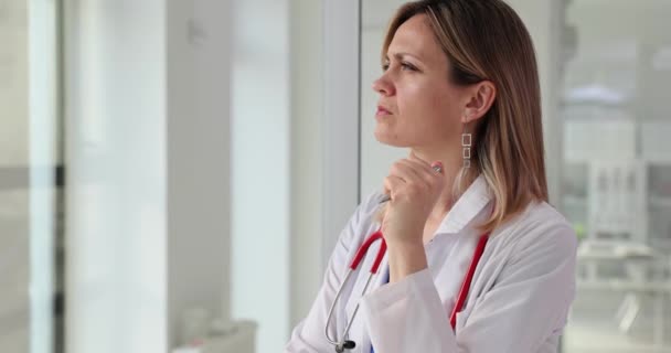 Pensive Female Doctor Looks Out Clinic Window Doubt Confidence Diagnosis — Stock Video