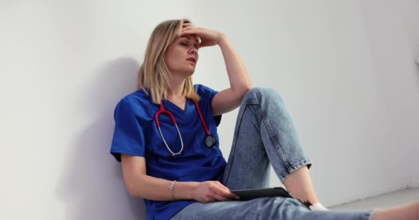 疲惫的护士坐在医院的地板上 医生精疲力竭和过度劳累 — 图库视频影像