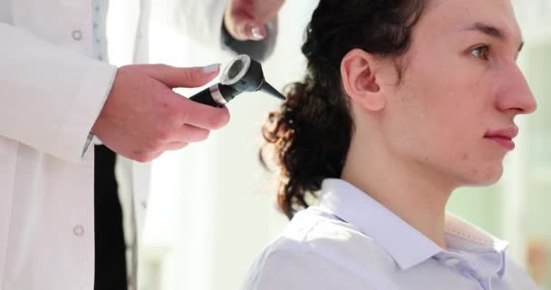 オトリガロジストはオットスコープを保持し 患者の耳を調べます 大人のための聴覚検査 — ストック動画