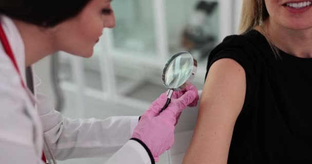 戴手套的医生手通过放大镜指向女性肩上的痣 摩尔人和皮肤癌的概念 — 图库视频影像