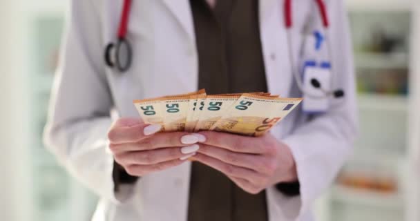身着医疗制服的护士正在把钱算入欧元 特写镜头 欧洲医生工资和医生工资的概念 — 图库视频影像