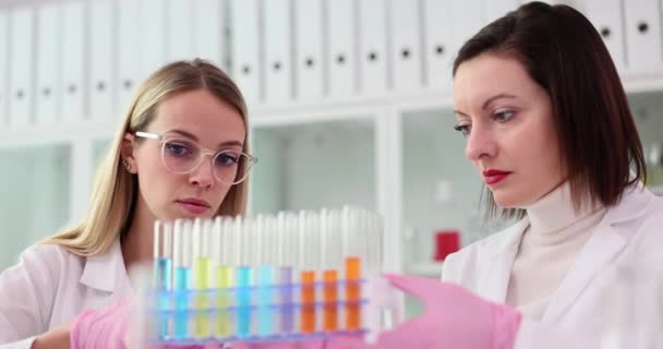 Due Scienziati Esaminano Attentamente Nuova Sostanza Liquido Multicolore Nelle Provette — Video Stock