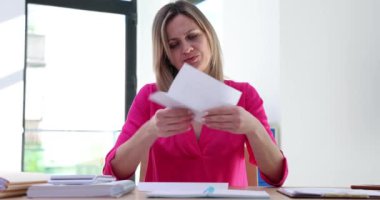 Stresli bir kadın, kötü haberle birlikte hayal kırıklığına uğramış bir mektup okuyor. İş kadını patronuna mali sorunlarla ilgili bir mektup geldi.