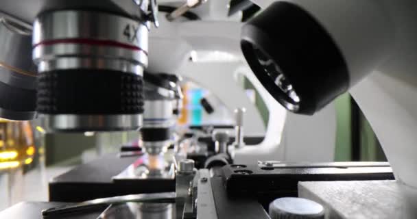 Σειρά Μικροσκοπίων Και Δοκιμαστικών Σωλήνων Έγχρωμο Υγρό Στο Εργαστήριο Εξέταση — Αρχείο Βίντεο