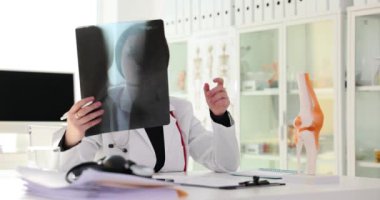 Kemik hastalığı ve ortopedik travma uzmanı insan bacağındaki diz yaralanmasını analiz ediyor. Hastanın dizinin klinikteki röntgen fotoğrafları.