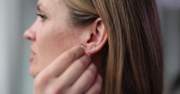 美しい女性は耳に長いイヤリングを置きます ジュエリーを選択する機能 — ストック動画