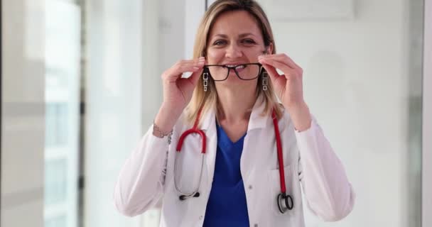 Médica Feminina Coloca Óculos Olha Para Câmera Seguro Serviços Médicos — Vídeo de Stock
