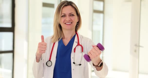 年轻医生妇女运动和节食使大拇指竖起 运动医生推荐健身 — 图库视频影像