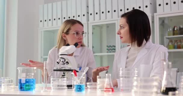 실험실의 과학자 얼굴에 혼란스러운 표현으로 현미경을 봅니다 의심의 개념과 과학적 — 비디오