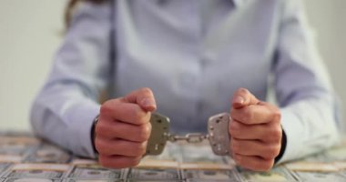 Kadın, elleri kelepçeli bir şekilde masanın üzerine kaldırdı. Ofiste nakit parayla kaplıydı. Yozlaşmış iş kadını yasadışı para aklamaktan tutuklandı
