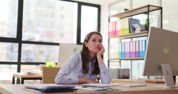 有思想的女人坐在办公室的电脑前 头脑清醒地看着掌心 员工们在无聊的一天都会在工作场所做梦 漂亮的公司员工 — 图库视频影像