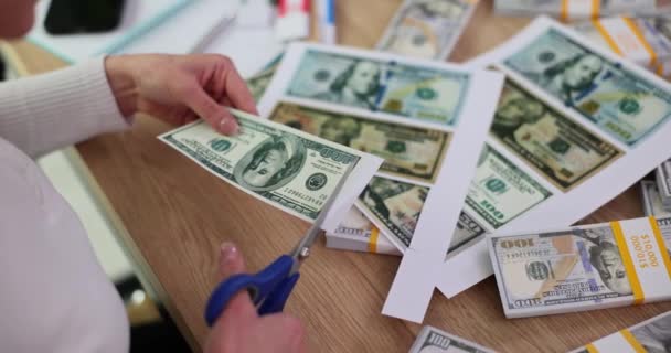 女人在桌上用剪刀修剪假钞的边缘 伪造者从办公室的纸片上剪掉钞票 非法行为或纪念品船 — 图库视频影像