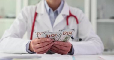Doktor klinikteki masada oturan paraları sayıyor. Tıbbi uzmanların ofisinde dolar banknotlarının hayranı var. Sağlık hizmetlerinin yüksek maliyeti