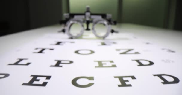眼科医のオフィスのテーブルに目のテストスナレン チャートに置かれた目のテスト装置 眼科医のオフィスで健康を改善するための高品質の眼科医療 — ストック動画
