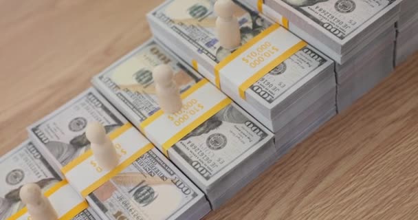 把一堆堆有组织的美元钞票作为台阶放在桌上 女商人在成捆的美元钞票上放上微型木制典当 以显示事业的缓慢发展 — 图库视频影像