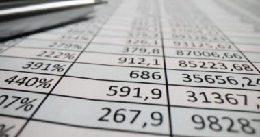 Rakamlı sütunlar ve iş tablosunda metal tükenmez kalem. Denetçi işyerindeki ticari bilgiler analiz ediliyor. Şirket geliştirme