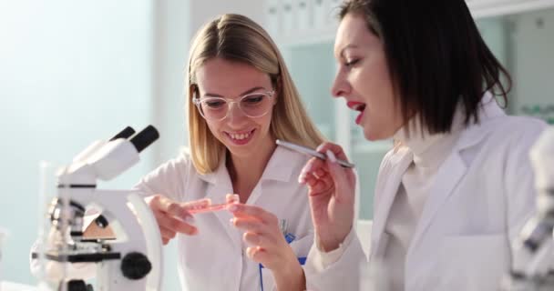 Vrouwelijke Mentor Legt Reactie Petrischaaltje Uit Aan Positieve Student Laboratorium — Stockvideo