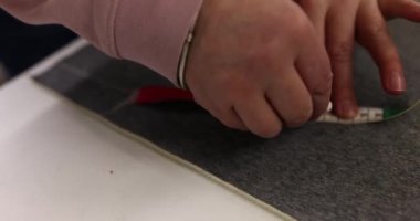 Terzi kadın ölçümleri metre şeridi ve tebeşirle yapıyor. Fabrikada el yapımı ve dikiş uzmanlığı. Kumaşlarla çalışmak