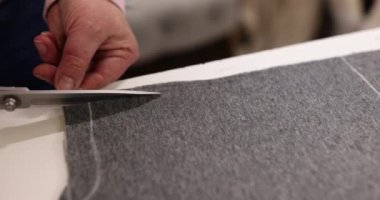 Terzinin elleri, özel dikim giysilerin özel dikimi için giysilerdeki işaretleri kesmek için makas kullanır. Kumaşlar ve moda tasarımı ile çalışmak