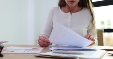 Kadın ofis çalışanı, aydınlık ofisteki yatırımcılarla yapılan iş toplantısında sunumdan önce masadaki verilere bakıyor. Çalışma anlarının iyileştirilmesi ve iş arkadaşlarıyla sorunların tartışılması