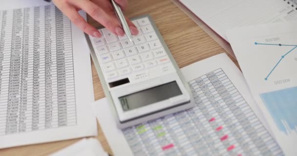 女会计使用表中的数据和计算器计算公司的费用 分配在公司工作的任务 收入计算 — 图库视频影像