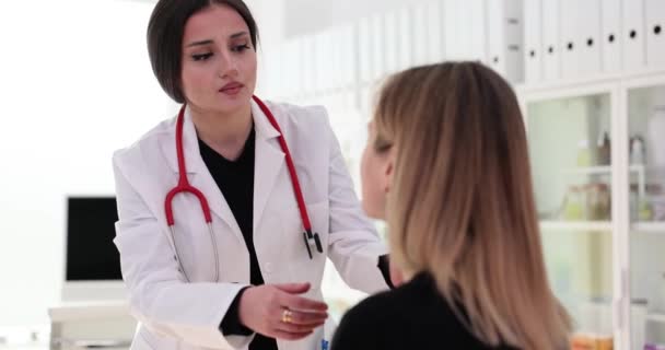 年轻的家庭妇女医生在办公室检查病人的喉咙 客户抱怨健康不佳和疼痛 专责人员的委任 — 图库视频影像