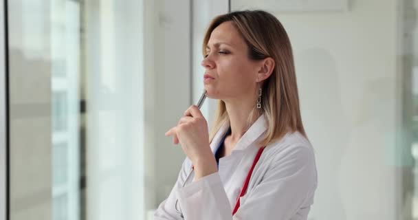 Επιμελής Γιατρός Στέκεται Στο Παράθυρο Κρατώντας Ασημένια Πένα Ξανθός Γιατρός — Αρχείο Βίντεο