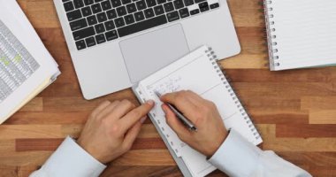 Profesyonel ofis çalışanı ödevlerini kağıt bloknotla tamamladı. Sorumlu yönetici düzenli kalır Yapılacaklar listesini planlayıcıda tutar
