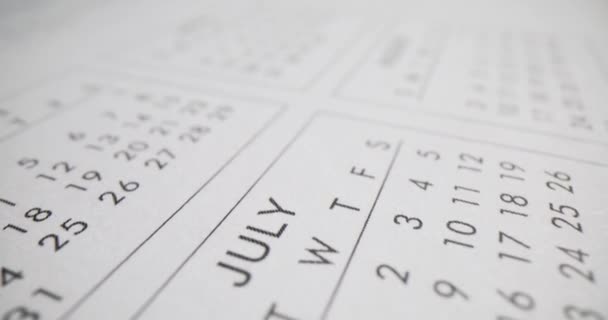 白いカレンダーのページに印刷された月と日付 ビジネスプランナーのページ オフィスで一年中 時間管理文房具の供給 — ストック動画