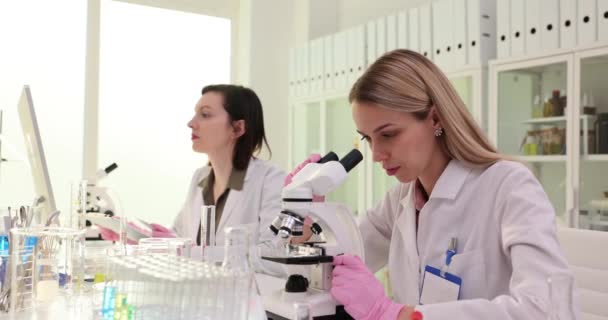 Lady Scientist Regarde Dans Les Microscopes Les Données Entrée Assistante — Video