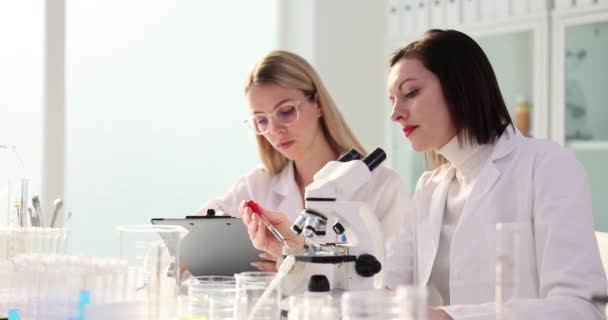 Женщины Исследователи Проводят Микроскопический Анализ Образца Лаборатории Опытные Ученые Исследуют — стоковое видео