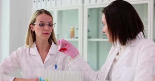 若い女性科学者は テストチューブで不快な液体を嗅ぎます 液体の遅い動きをひどく嗅ぐことを調査する修飾された研究者 — ストック動画