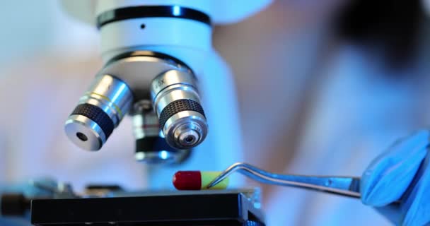 Pesquisador Competente Estuda Cápsula Colorida Droga Usando Microscópio Poderoso Laboratório — Vídeo de Stock