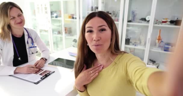 Uśmiechnięta Kobieta Nagrywa Wideo Chwaląc Lekarza Doskonałą Opiekę Spotkaniu Młode — Wideo stockowe