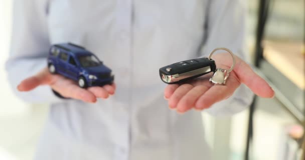 汽车经销店经理在沙龙里展示了玩具车和顾客的钥匙 推销员向客户提供营销和销售运输的概念 — 图库视频影像
