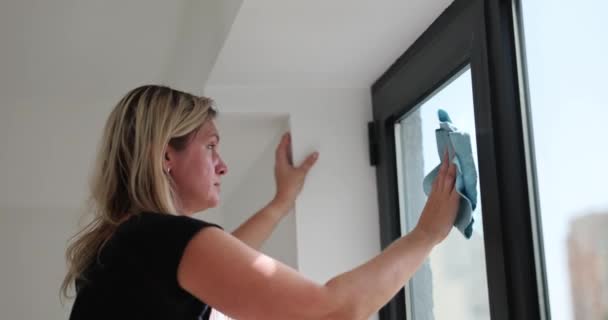 疲惫的女人在高层办公大楼里用抹布擦窗户 少女做卫生家务活 维护家里的秩序 家庭主妇的日常慢动作 — 图库视频影像