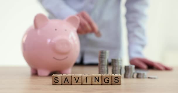 木製の立方体と女性のコインをテーブルの上に投げる節約 レディは将来の支出のためにお金を貯めている ファミリー予算 — ストック動画