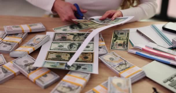 女性フォージャーは キャビネットのテーブルに座っているハサミと偽の印刷されたお金をカットします オフィスの遅い動きの支払いのための偽ドル紙幣の製造 — ストック動画