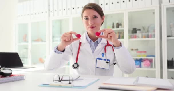Γιατρός Κάθεται Στο Τραπέζι Και Επιδεικνύει Μικροσκοπικές Καρδιές Γιατρός Χρησιμοποιεί — Αρχείο Βίντεο