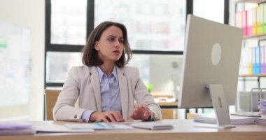 Esmer kadın, ofis bilgisayarındaki online konferansa başlamadan önce gergin. Genç işçilerin zihinleri için üzücü ve yorucu düşünceler.
