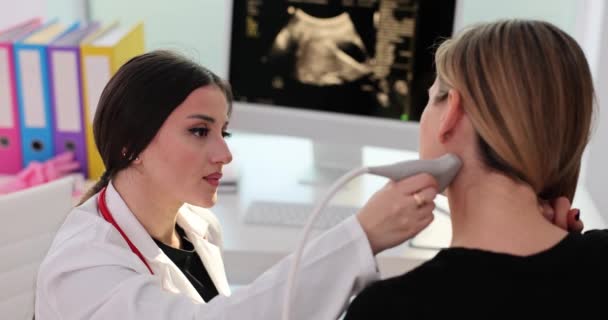 女性患者は私立診療所で超音波検査を受けます 熟練した女性医師は慎重にスクリーンを見ている患者のリンパ節を調べます — ストック動画