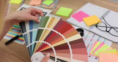 Tasarımcı, müşteri için modern karar oluşturmak için palet üzerine renk seçer. Kadın, beklentileri aşmak için yaratıcılık ve uzmanlık aşılıyor.