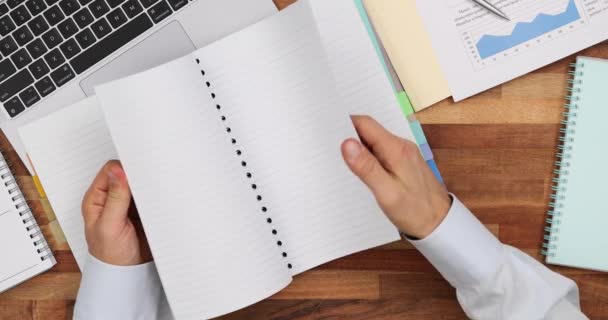 Бизнесмен Открывает Бумажную Тетрадь Работающую Столом Ноутбуком Человек Перелистывает Страницы — стоковое видео