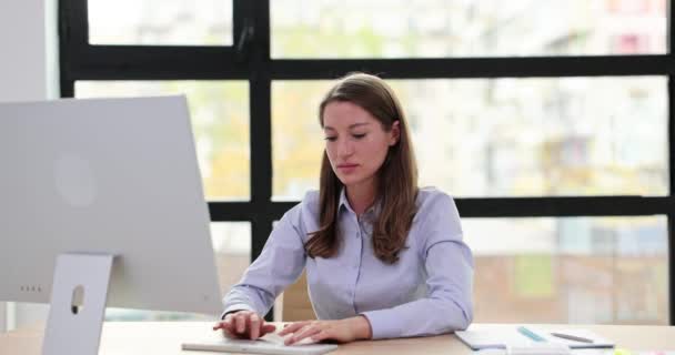 年轻的女人工作在计算机类型 看着相机 挥挥手道别 办公室的商务礼仪 — 图库视频影像