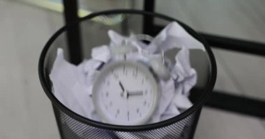 Kırık kağıt ve bozuk çalar saati olan bir ofis çöpü kutusu. Zaman yönetimi son teslim tarihi ve iş fikirlerinin yaratıcı krizi