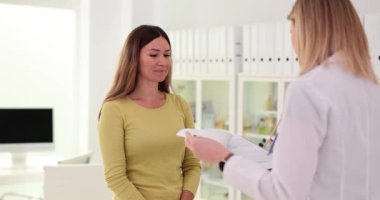 Neşeli kadın hasta modern klinikteki ilgili doktordan iyi haberler alıyor. Bir jinekologdan hamilelik ve olumlu haberler.