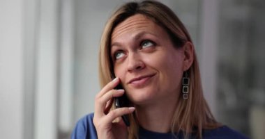 Gülümseyen kadın yorgun ve telefonda konuşuyor. Müşteri ile iletişimde tatminsizlik hissi